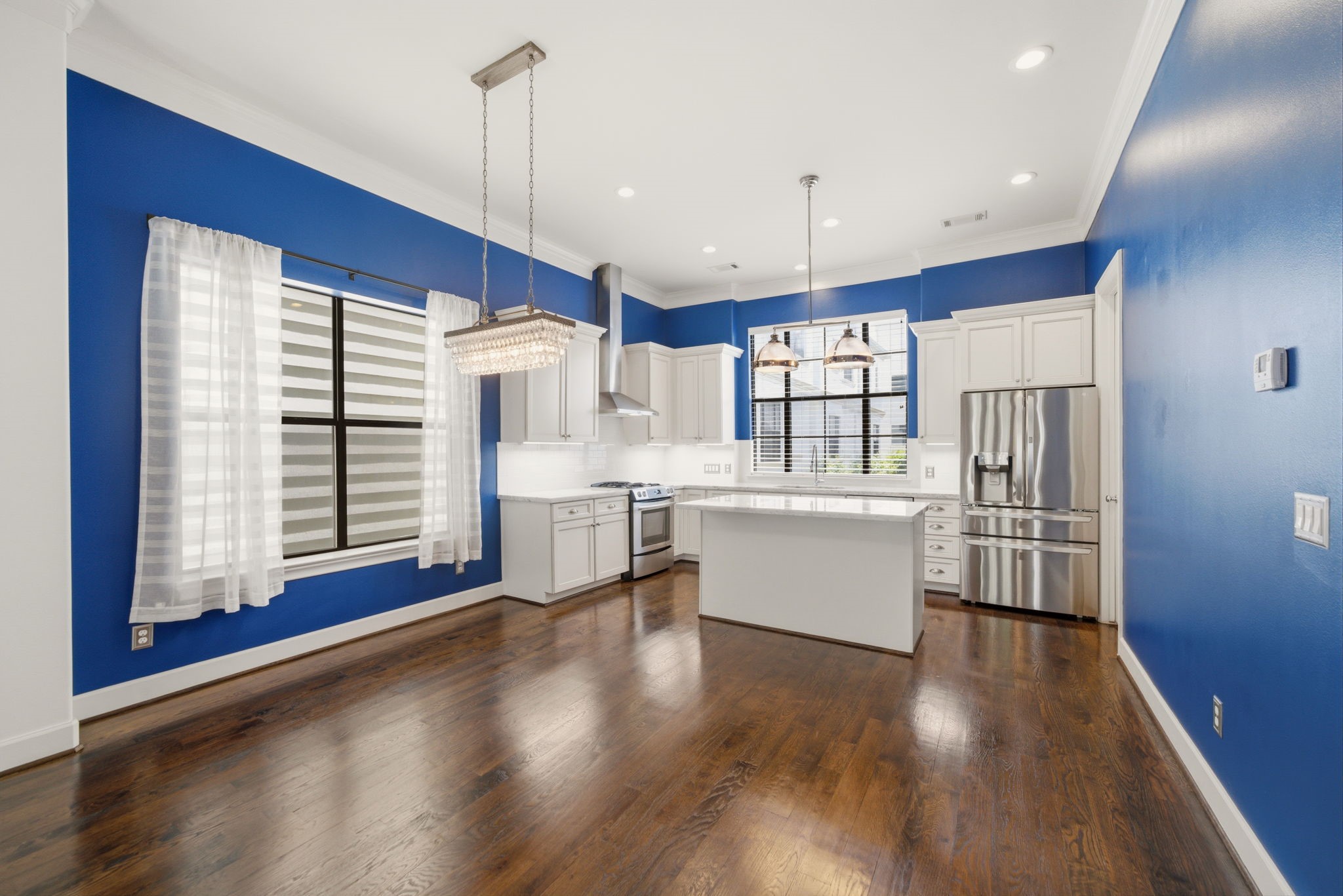 911 West Drew Street Houston, TX 77006 - Photo 14 of 44 a kitchen with stainless steel appliances kitchen island granite countertop a refrigerator a sink dishwasher a stove and white countertops with wooden floor