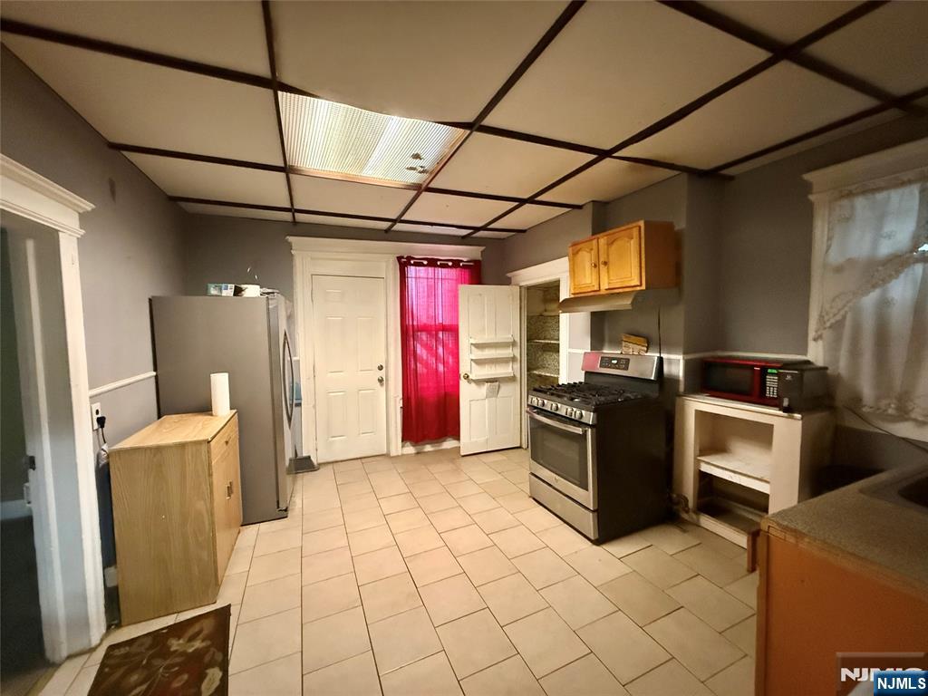 304 Harrison Avenue, Unit 1) Harrison, NJ 07029 - Photo 3 of 15 a kitchen with granite countertop a refrigerator and a stove