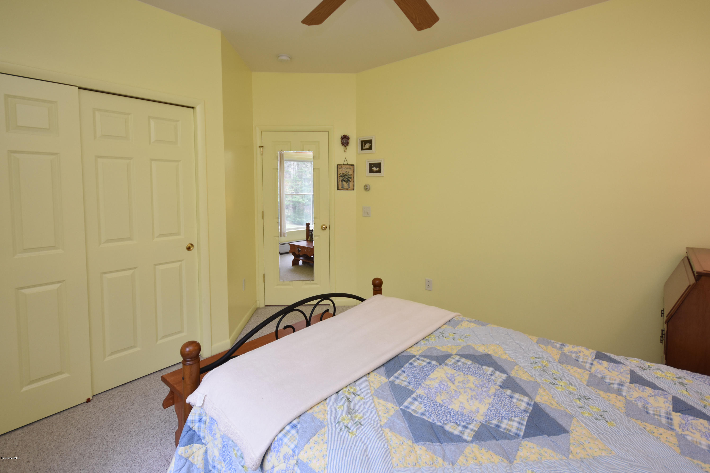 555 West Center Road Otis, MA 01253 - Photo 35 of 49 a bedroom with a bed and a chandelier