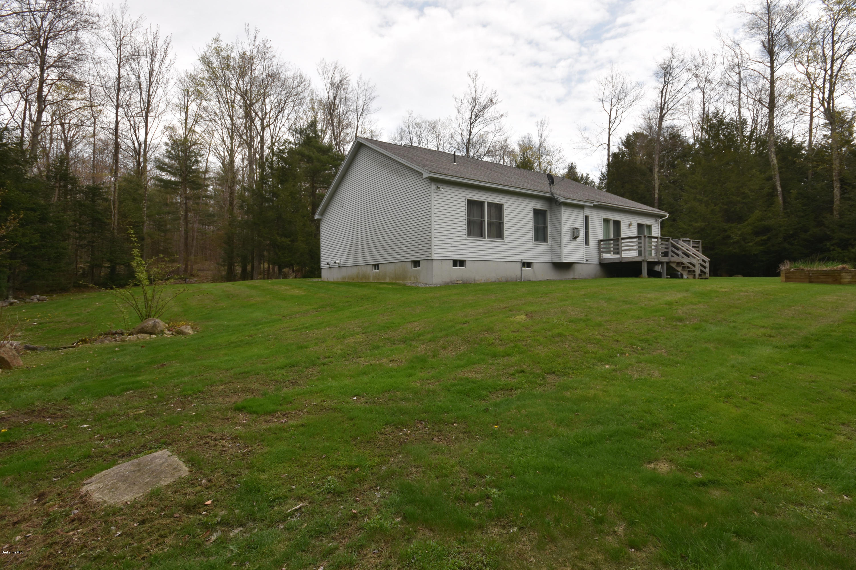 555 West Center Road Otis, MA 01253 - Photo 42 of 49 a house that is sitting in the grass with large trees and plants