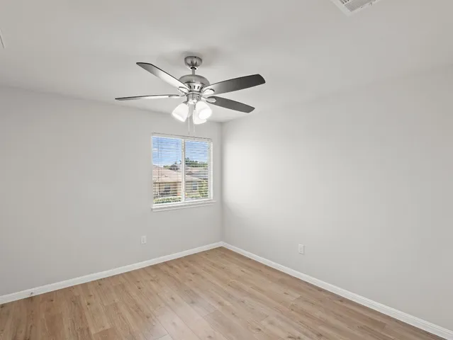 an empty room with a window and a fan