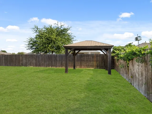 a view of a backyard with a garden and deck