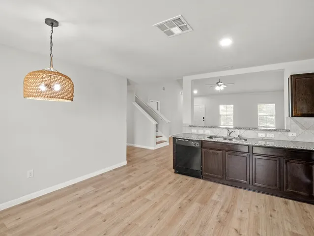 a large kitchen with stainless steel appliances granite countertop a sink and a wooden floor