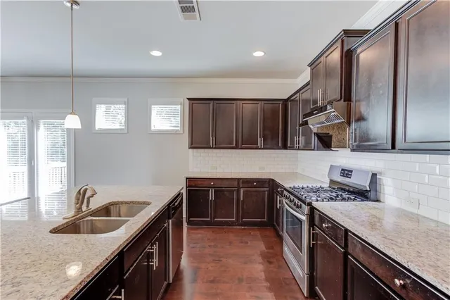 a kitchen with stainless steel appliances granite countertop a sink stove and cabinets
