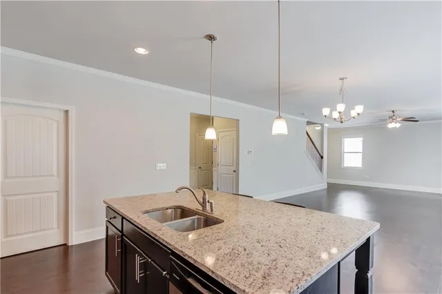 a kitchen with a sink chandelier and wooden floor