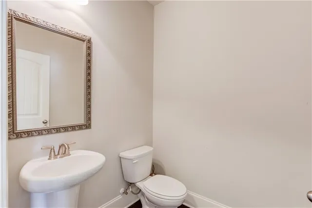 a bathroom with a toilet a sink and mirror