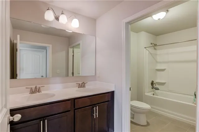 a bathroom with a sink vanity granite toilet tub and shower