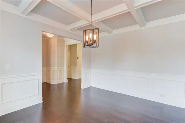 a view of a hallway with wooden floor and chandelier