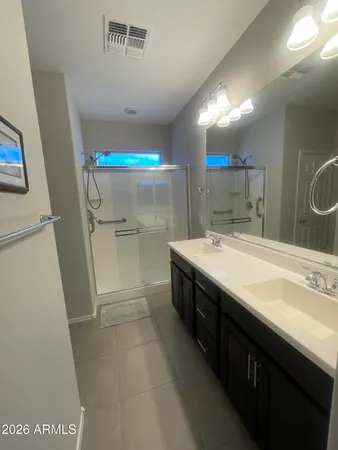a bathroom with a double vanity sink mirror and shower