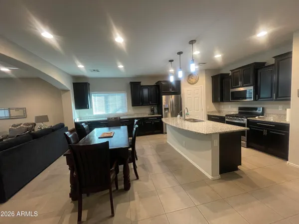 a large kitchen with kitchen island a sink table and chairs