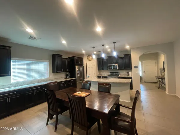 a kitchen with a sink and chairs