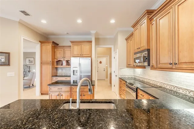 a kitchen with granite countertop a refrigerator and countertop