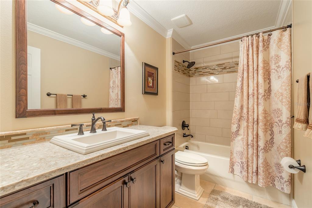 10915 Ledgement Lane Windermere, FL 34786 - Photo 32 of 60 a bathroom with a granite countertop sink toilet a large mirror a shower and a bathtub