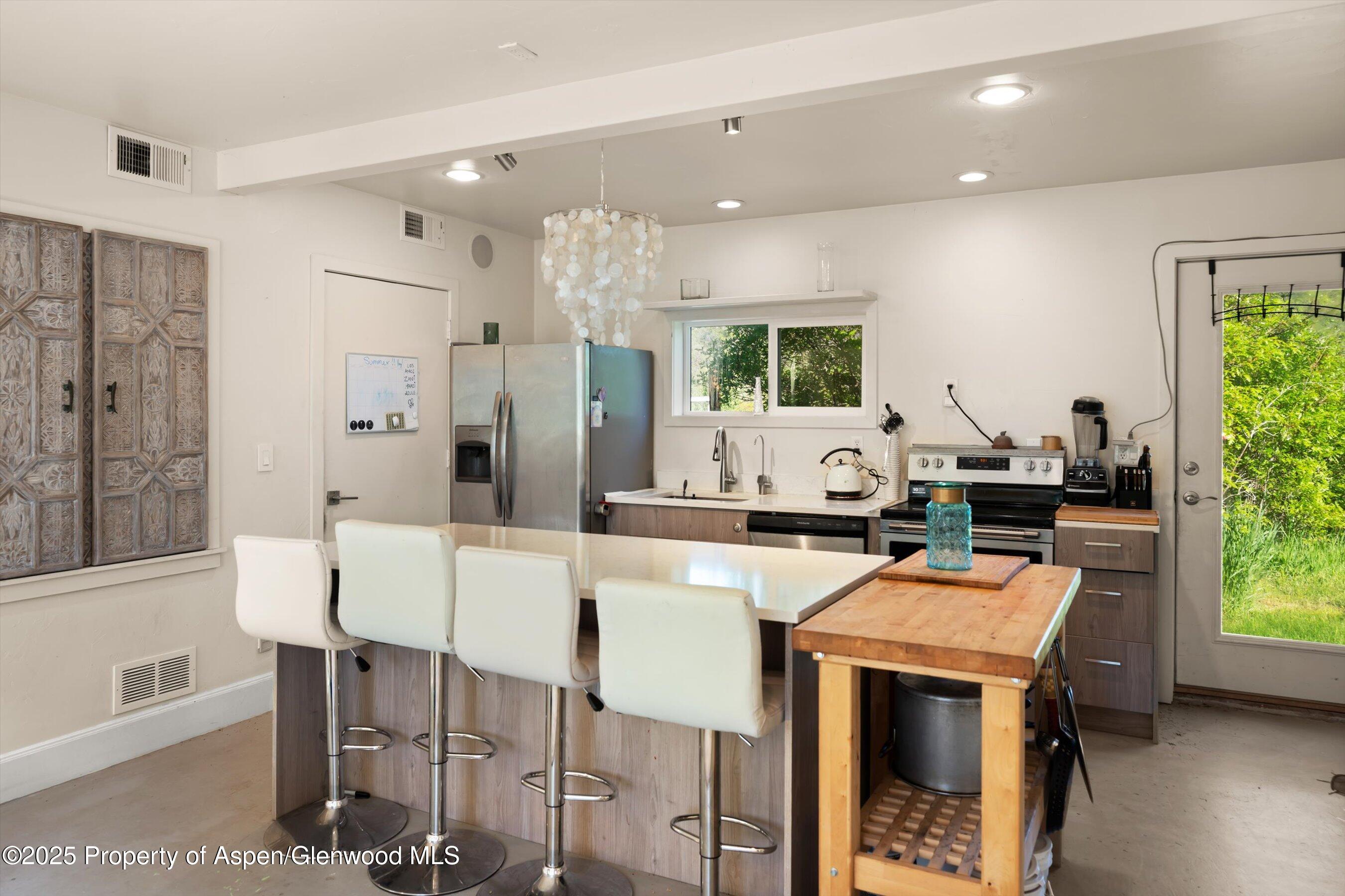 2240 Old Herron Road Basalt, CO 81621 - Photo 23 of 42 a kitchen with stainless steel appliances granite countertop a stove a refrigerator a oven a white table and chairs