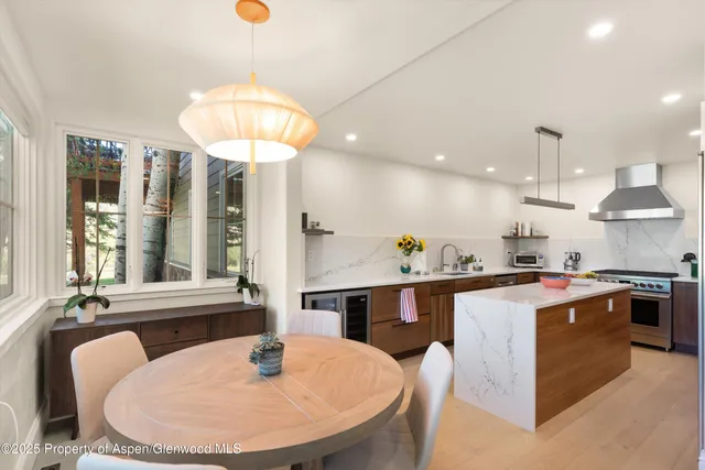 a view of a dining room with furniture a chandelier and wooden floor