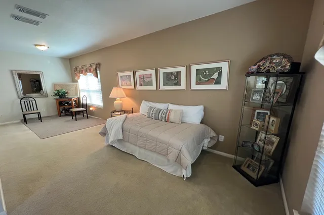 a bedroom with a bed a couch and dresser