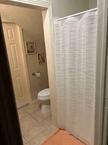 a bathroom with a toilet and a shower curtain
