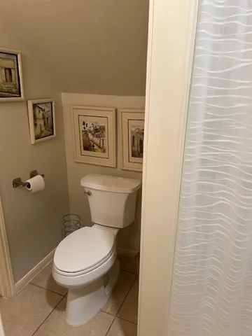 a white toilet sitting next to a white wall