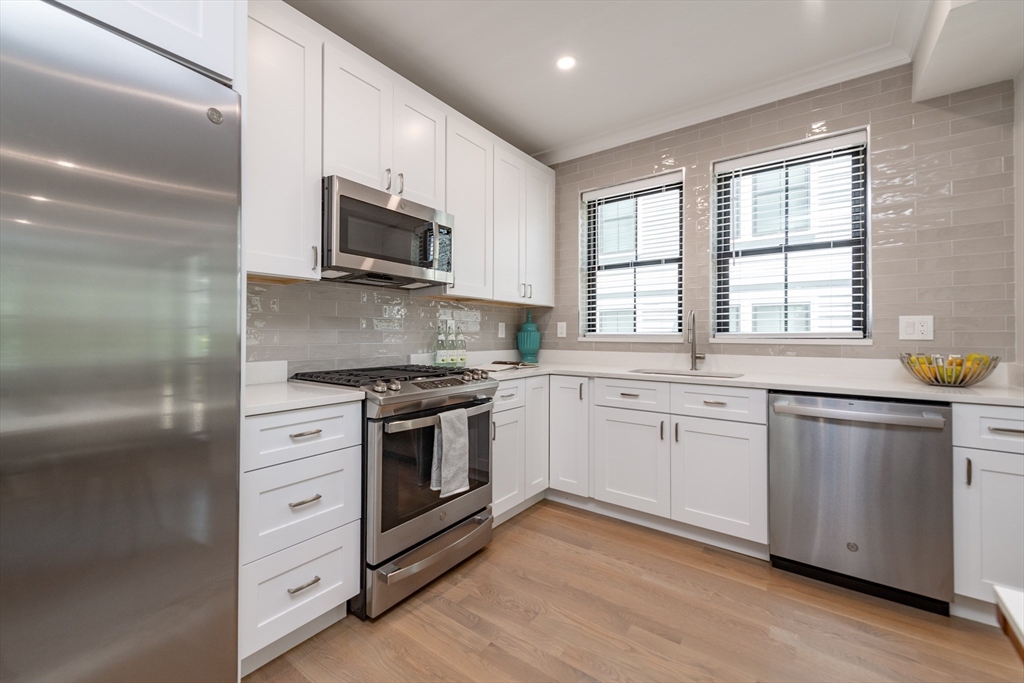 281 Lamartine Street Boston, MA 02130 - Photo 4 of 14 a kitchen with stainless steel appliances granite countertop white cabinets a sink and a stove