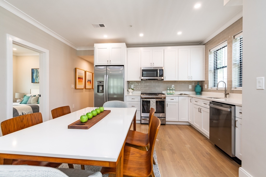 281 Lamartine Street Boston, MA 02130 - Photo 5 of 14 a kitchen with stainless steel appliances kitchen island granite countertop a refrigerator a stove top oven a sink dishwasher and white countertops with wooden floor