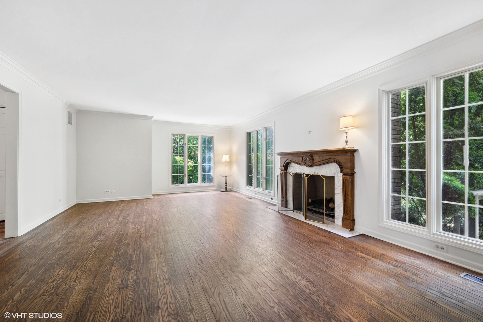 1100 Turicum Road Lake Forest, IL 60045 - Photo 7 of 38 an empty room with windows a fireplace and wooden floor