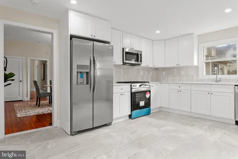 a kitchen with stainless steel appliances a refrigerator sink and cabinets