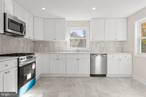 a kitchen with white cabinets stainless steel appliances and sink
