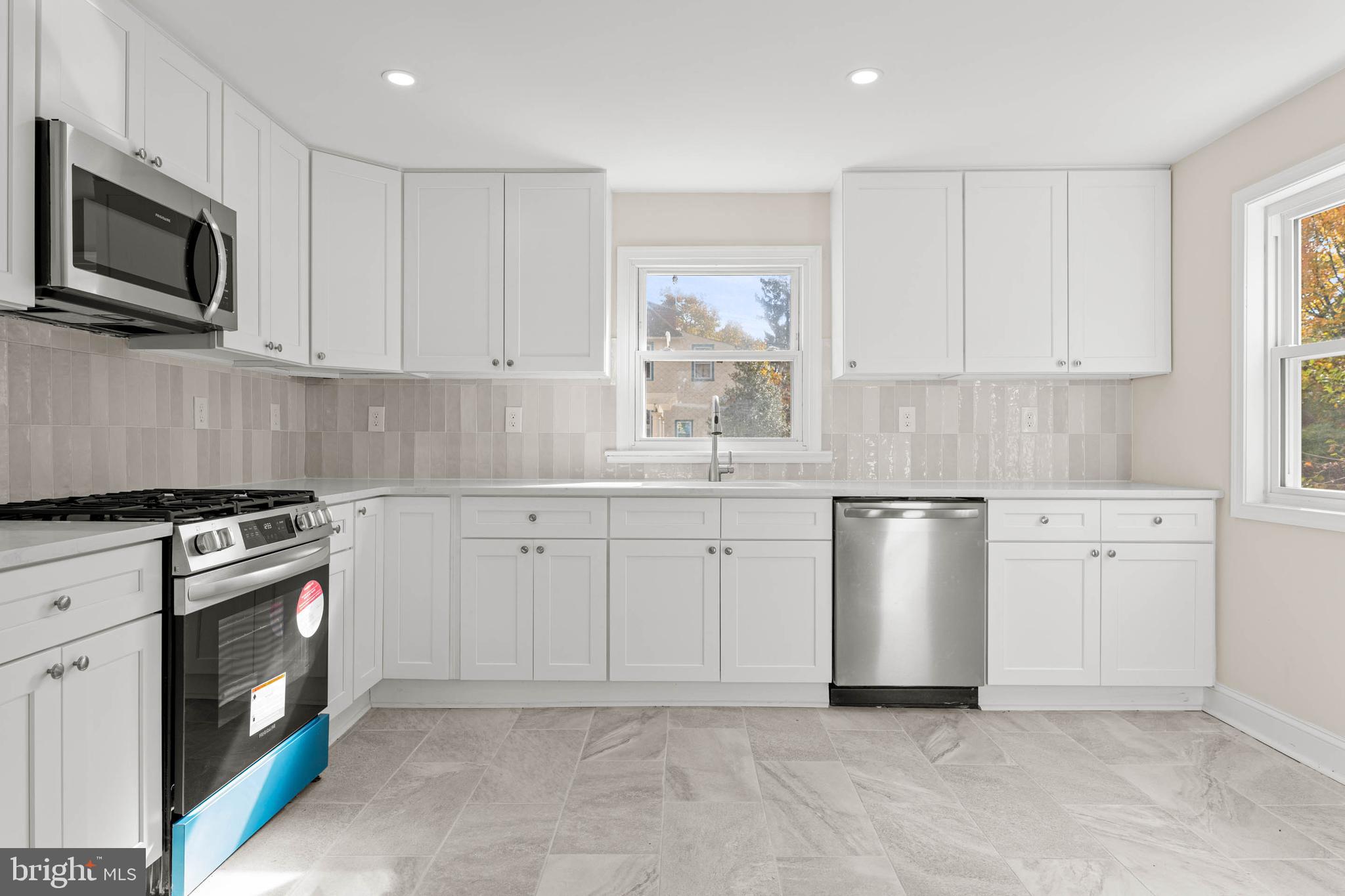 115 President Avenue Rutledge, PA 19070 - Photo 12 of 34 a kitchen with white cabinets stainless steel appliances and sink