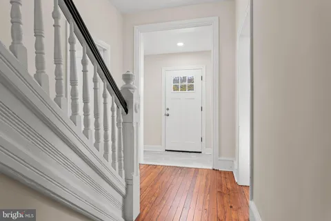 a view of a hallway with wooden floor and staircase