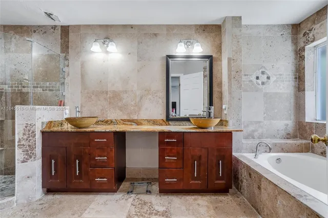 a spacious bathroom with a tub sink and mirror