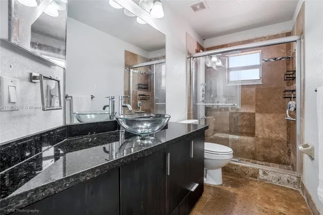 a bathroom with a double vanity sink toilet and shower