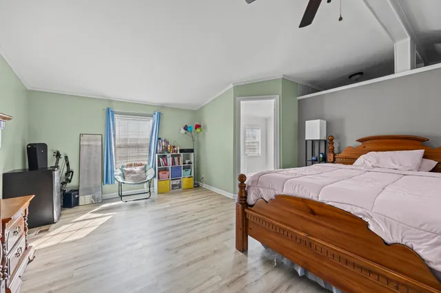 a bedroom with a bed and wooden floor