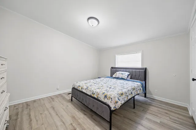 a bedroom with a bed and wooden floor