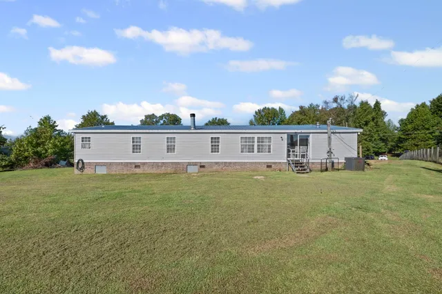 a view of a house with backyard and trees