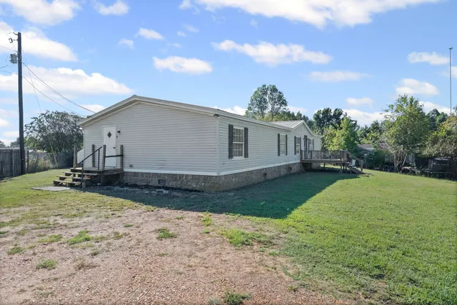 a front view of a house with a yard and trees