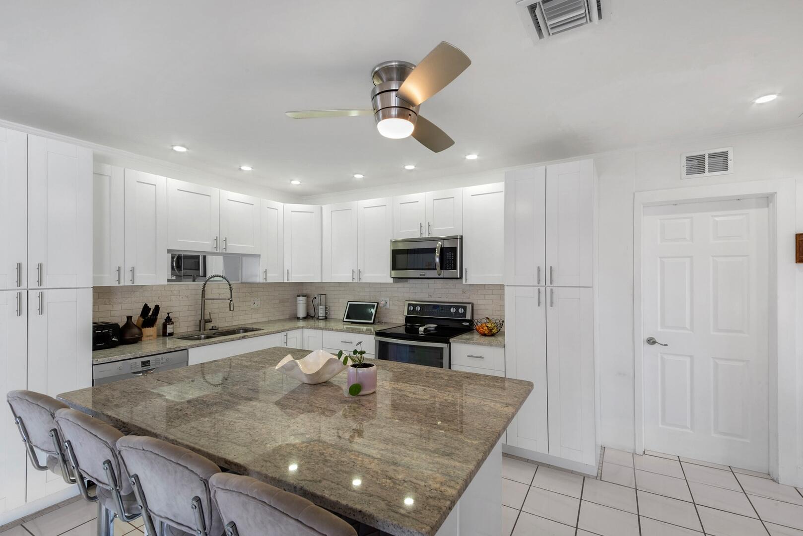 220 Southeast 2nd Avenue Pompano Beach, FL 33060 - Photo 13 of 43 a kitchen with stainless steel appliances granite countertop a sink a stove a refrigerator cabinets and living room view