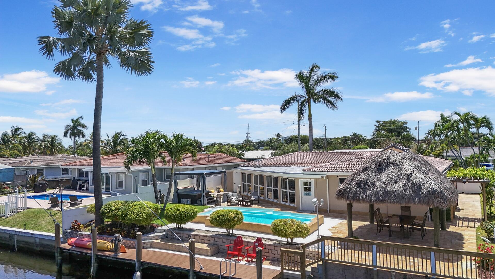220 Southeast 2nd Avenue Pompano Beach, FL 33060 - Photo 31 of 43 a view of a patio with couches table and chairs potted plants and palm tree