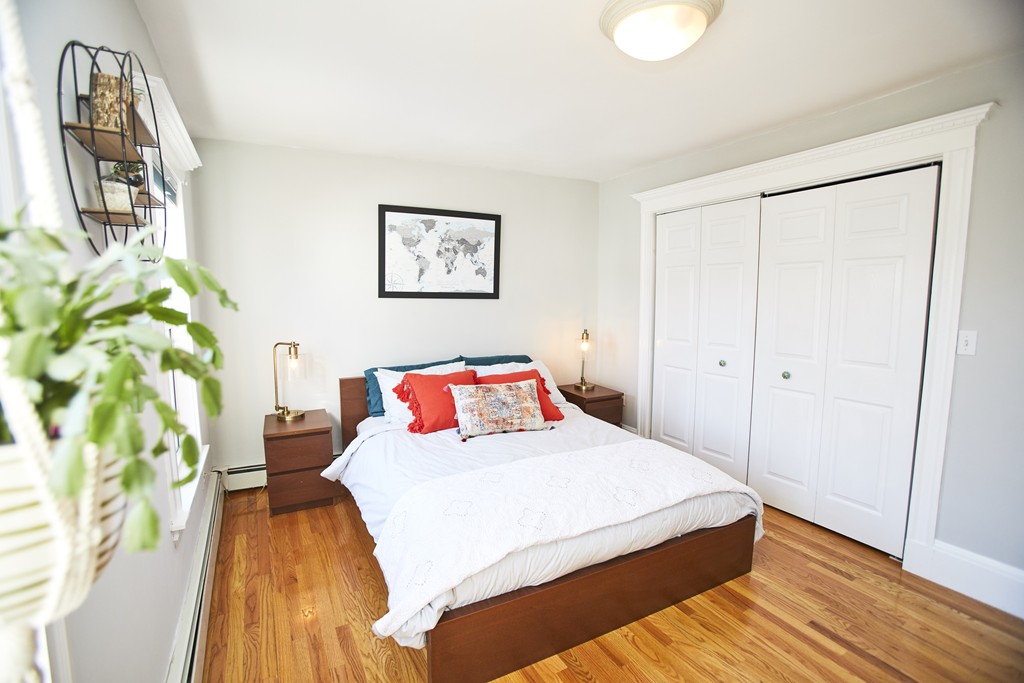 56 Hinckley Street, Unit 2 Somerville, MA 02145 - Photo 11 of 18 a bedroom with a bed and a painting on the wall