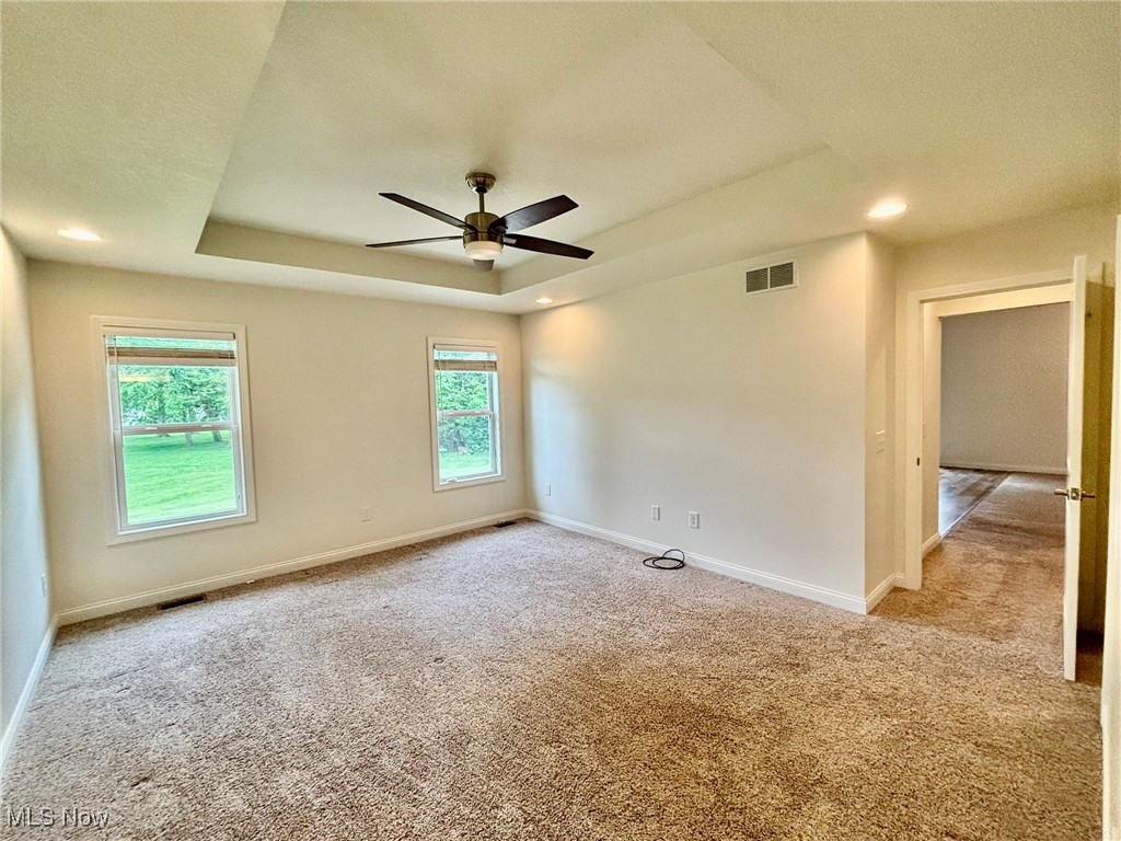 1132 Hummingbird Way Findlay, OH 45840 - Photo 15 of 28 Unfurnished room featuring a tray ceiling, light colored carpet, a ceiling fan, and recessed lighting