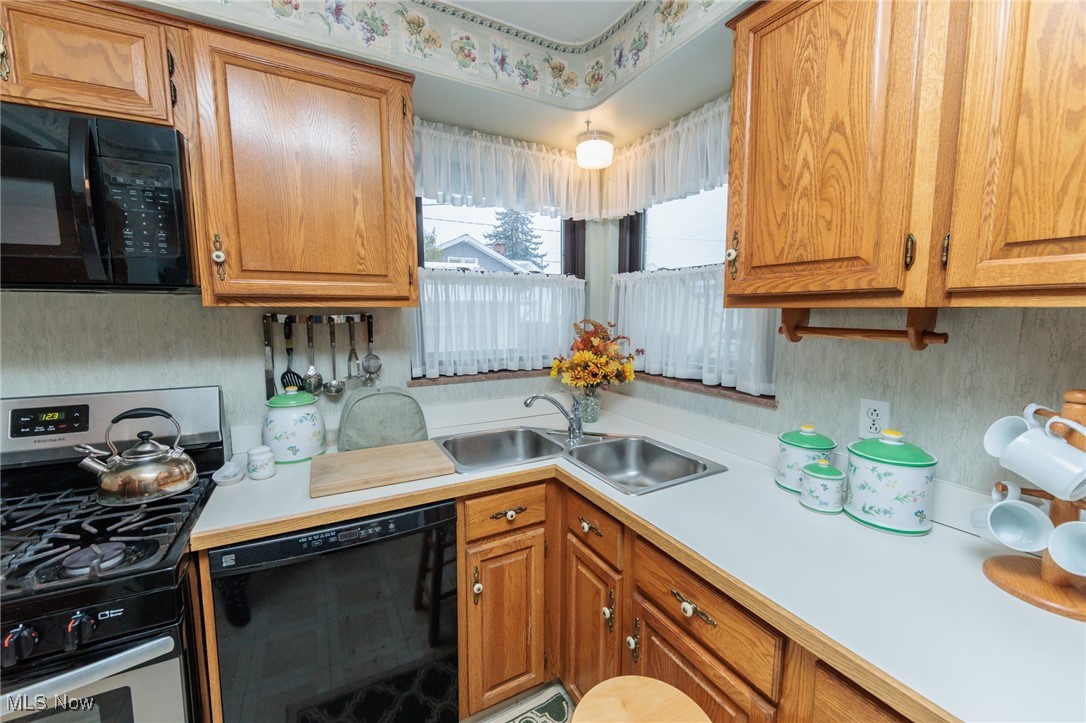 6192 Stanbury Road Parma, OH 44129 - Photo 27 of 49 Kitchen featuring black appliances, light countertops, and brown cabinets