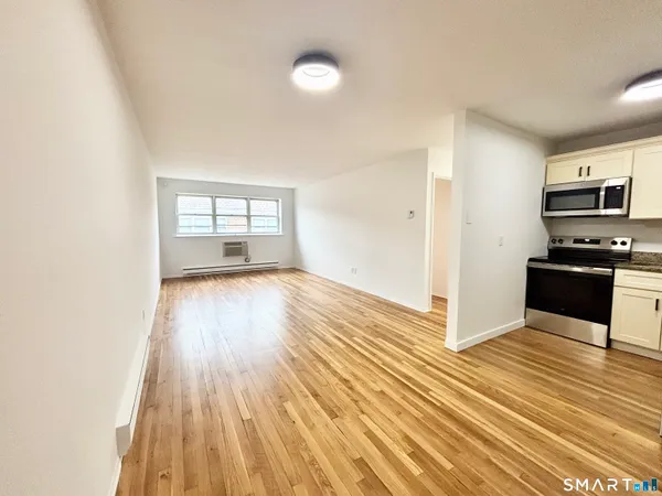 a kitchen with wooden floors and wide window