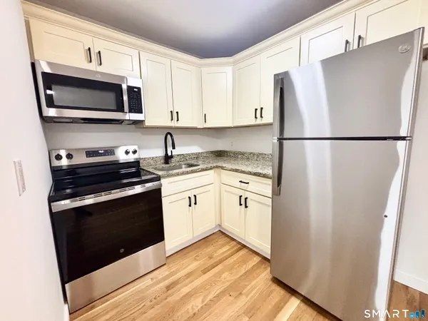 a kitchen with stainless steel appliances a refrigerator stove and microwave