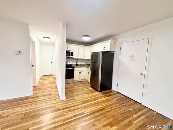 a view of a kitchen with wooden floor and a refrigerator