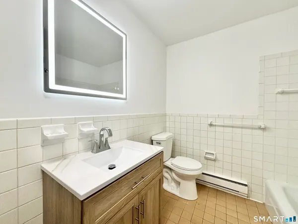 a bathroom with a sink mirror and toilet