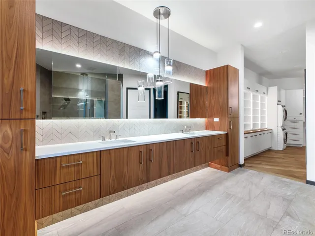 a large kitchen with stainless steel appliances a large counter top a sink a refrigerator and a window