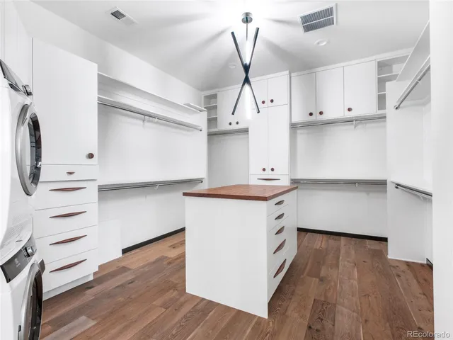 a kitchen with stainless steel appliances a stove and white cabinets with wooden floor