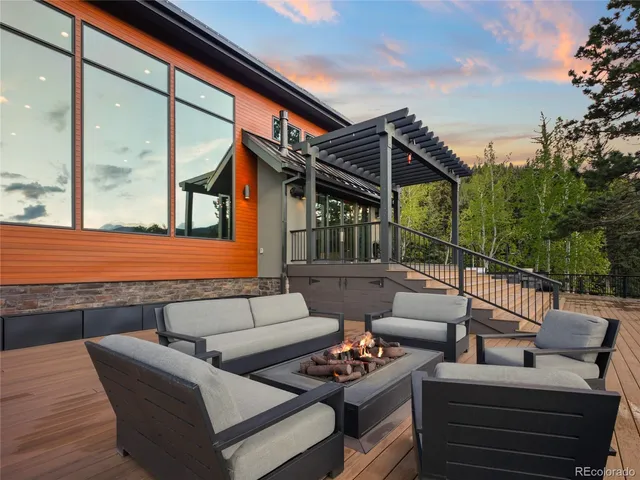 a roof deck with couches and potted plants