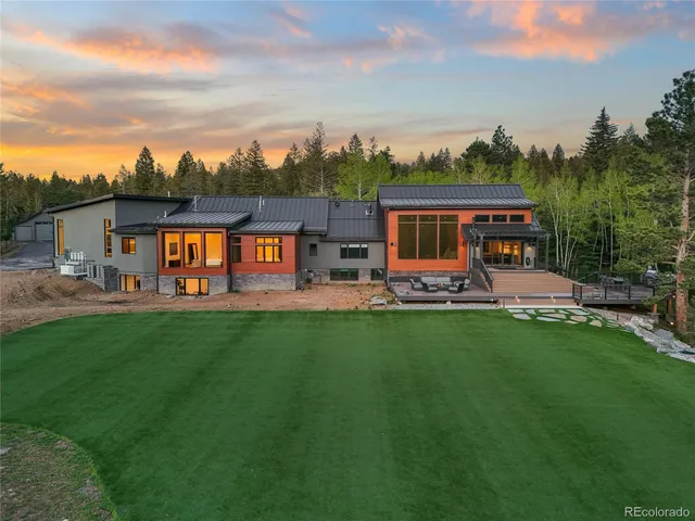 a view of a house with backyard outdoor seating area and trees