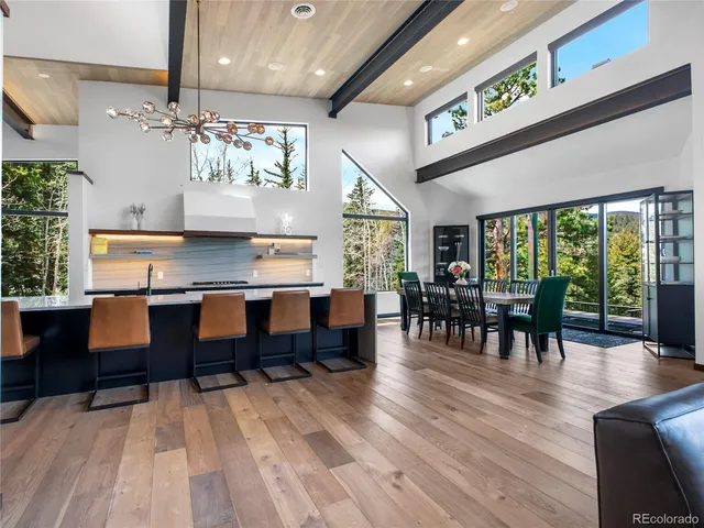 a open kitchen with stainless steel appliances granite countertop a dining table chairs stove a refrigerator and kitchen view