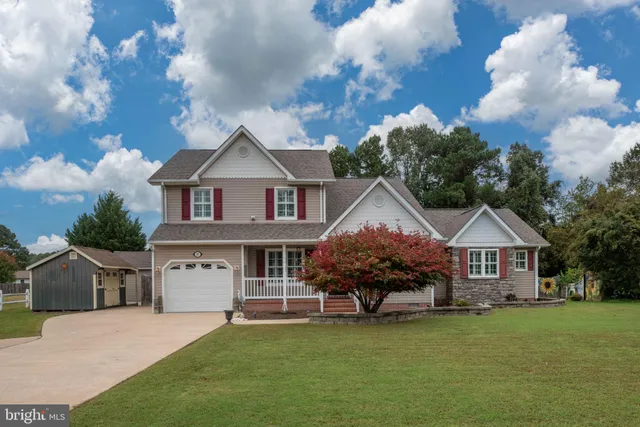 a front view of a house with a garden and trees